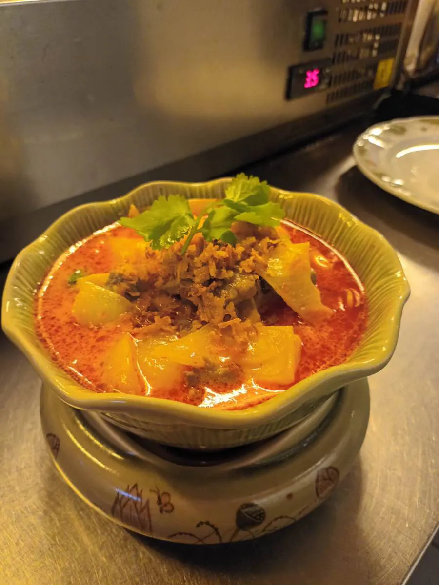 Suppe mit Kürbis und Hackfleisch im Tontopf